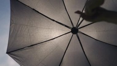 Şemsiye güneşten korur. Gökyüzüne karşı şık bir şemsiye