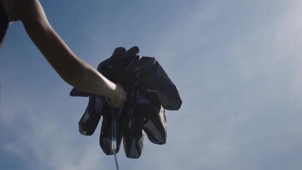 Flickan lägger ut ett paraply mot den blå himlen. — Stockvideo