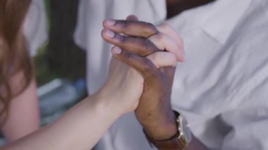Siyah ve beyaz bir el birbirine dolanmış. Romantik bir randevuda bir erkek ve bir kadın. Irklar arası ilişkiler normdur..