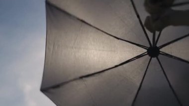 Şemsiye güneşten korur. Gökyüzüne karşı şık bir şemsiye
