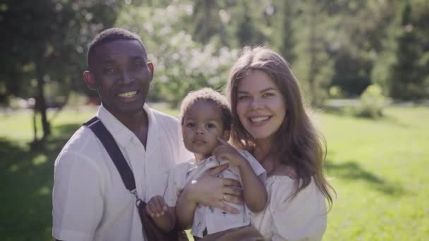 Giovane famiglia multirazziale nel parco. Madre padre e bambino sono felici insieme. — Video Stock
