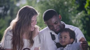 Parktaki çok kültürlü aile. Anne, baba ve oğul birlikte harika vakit geçiriyorlar..