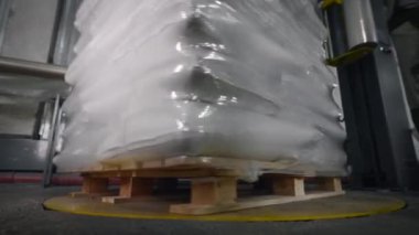 Çantalı bir palet özel bir makine kullanılarak folyoya konur..