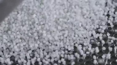 Titreşen bir masada plastik granüller. Polimer bileşik üretim