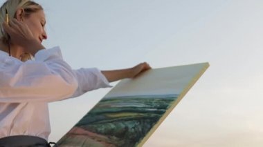 Genç kadın rahatlar ve yavaş çekimde bir resim çizer..