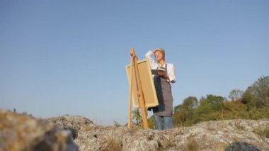 Profesyonel bir sanatçı yağlı boyalarla resim yapar..