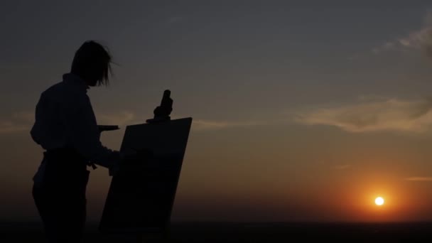 लड़की कलाकार ग्रामीण क्षेत्र में सूर्यास्त पर तेल पेंट्स की तस्वीर बनाता है . — स्टॉक वीडियो