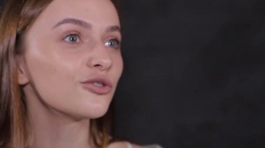 Kadın siyah arka planda konuşuyor..