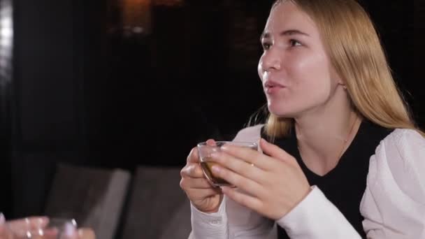 Het meisje drinkt warme thee en warmt zichzelf op door de beker te knuffelen — Stockvideo