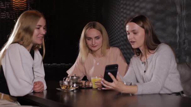 En grupp tjejer använder en smartphone och kommunicerar aktivt — Stockvideo