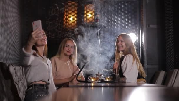 Sekelompok gadis muda merokok hookah dan menghembuskan asap putih. — Stok Video