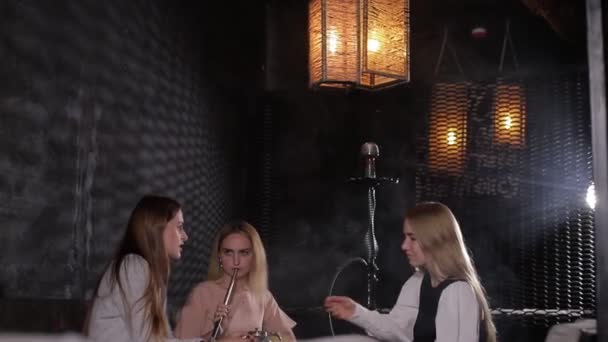 Drei Mädchen im Teenageralter ruhen sich in einem Café aus und reden miteinander