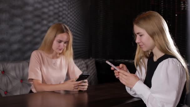 여자 친구들이 손에 스마트폰을 들고 이야기하고 차를 마시는 모습 — 비디오