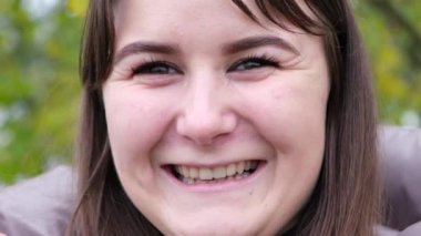 Mutlu ve gülümseyen esmer kız kameraya bakıyor..