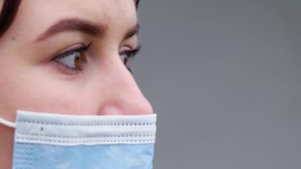 Meisje met een blauw medisch masker. Close-up gezicht portret van een meisje. — Stockvideo