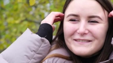 Elinde bir buket sonbahar çiçeği tutan esmer kadın..