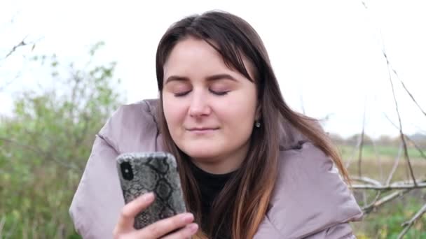 Fille utilise son smartphone sur une balançoire dans le parc — Video