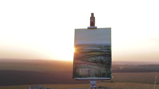 Pittura in piedi su un cavalletto in campagna al tramonto — Video Stock