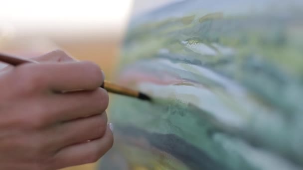 Chica artista pinta un cuadro en un caballete. Artista profesional en el trabajo — Vídeos de Stock