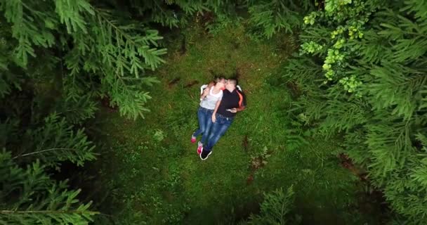 Щаслива пара в лісі дивиться на високі дерева — стокове відео