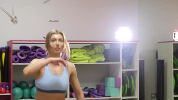 Krásná fitness žena se zvedacími činkami. Sportovní dívka ukazuje své dobře vycvičené tělo. Dobře vyvinuté svaly silovým tréninkem. — Stock video