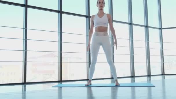 Девушка выполняет упражнения, чтобы тренировать ноги в тренажерном зале — стоковое видео