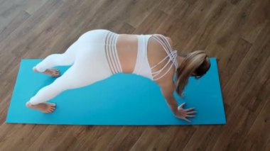 Atletik kız spor salonunda vücut esnekliği için bir takım egzersizler yapıyor.