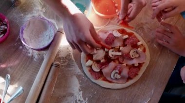 Çocuklar bir aşçıyla pizza pişirir..