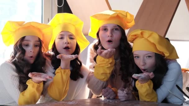 Children in yellow hats help to cook pizza in the kitchen. — Stock Video