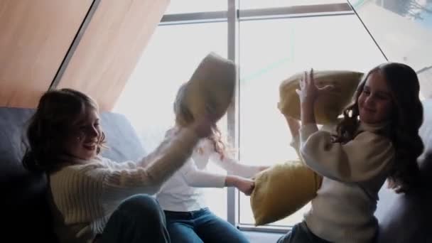 Три девушки играют в боевые подушки. — стоковое видео