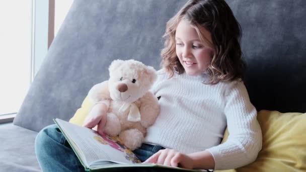 Portret van een ontspannen zorgeloos kind dat thuis literatuur geniet. — Stockvideo