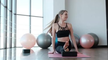 Uzun bacaklı bir kız spor yapıyor. Esneme egzersizleri yapıyor. Genç fitness modelinde antrenman yapıyor.