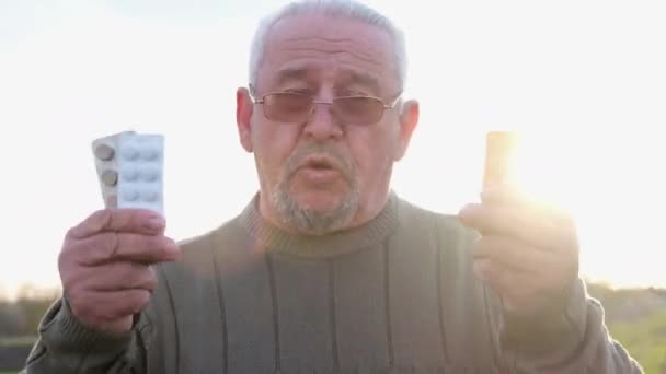 Retrato de un hombre adulto maduro con pastillas en las manos. — Vídeo de stock