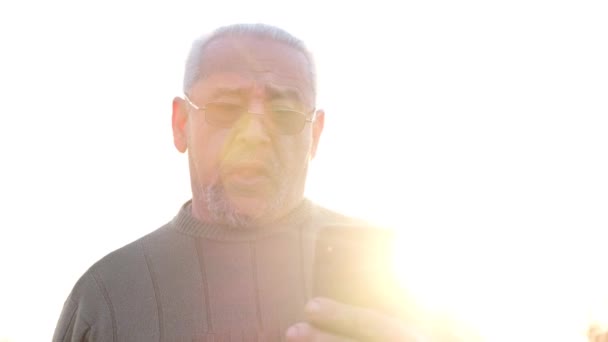 Dojrzały stary siwowłosy dziadek ze smartfonem w rękach — Wideo stockowe
