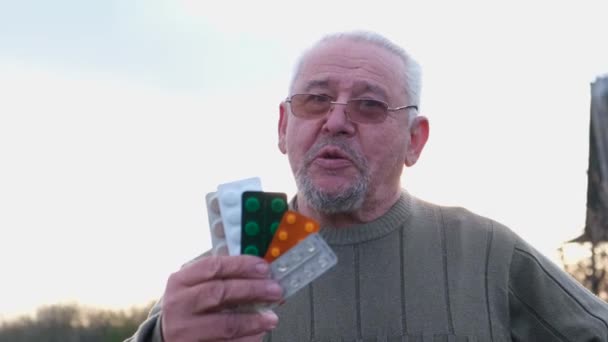 Grootvader met pillen in zijn handen. Gelukkige man van de pensioenleeftijd — Stockvideo