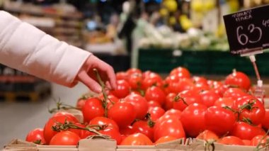 Kız süpermarketten domates alıyor, doğal ürünler.