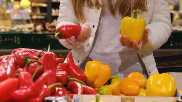 Αγοράζεις λαχανικά στην αγορά. Επιλογή κόκκινες και κίτρινες πιπεριές. — Αρχείο Βίντεο