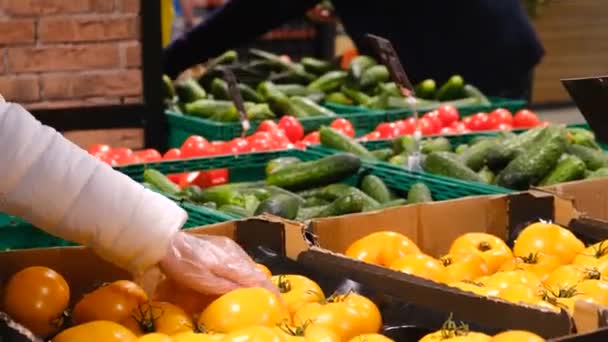 Женщина выбирает овощи из коробок в супермаркете. — стоковое видео