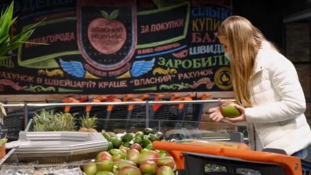 Junge Frau kauft Mangos auf dem Obstmarkt. — Stockvideo