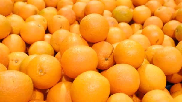 Narancs egy dobozban a szupermarketben. a termesztett érett, friss narancs háttere — Stock videók