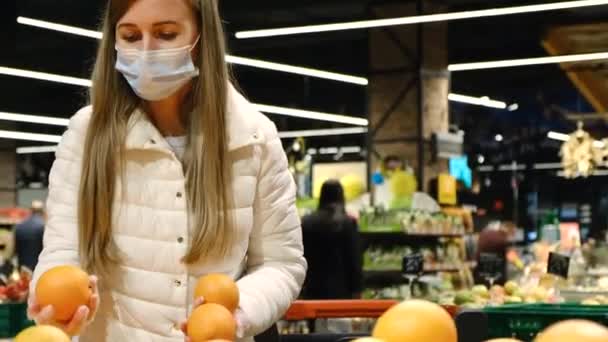 Une jeune femme achète des oranges au marché aux fruits. Fruits sucrés mûrs. — Video