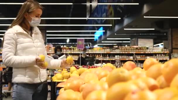 Νεαρή γυναίκα αγοράζει πορτοκάλια στην αγορά φρούτων. Ώριμα γλυκά φρούτα. — Αρχείο Βίντεο