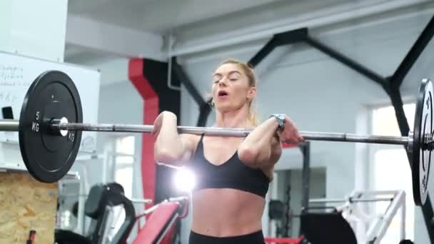 Atletik kadın halterle egzersiz yapıyor, spor salonunda halter eğitimini kaldırıyor.. — Stok video