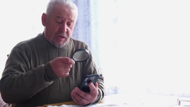 Viejo abuelo utiliza un teléfono inteligente. — Vídeos de Stock