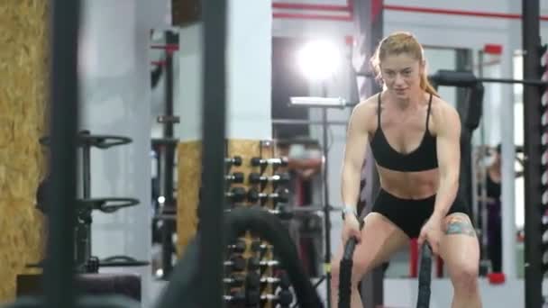 Mujer joven haciendo algunos ejercicios crossfit con una cuerda . — Vídeos de Stock