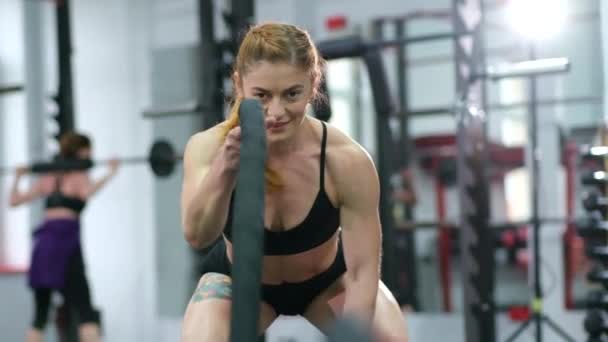 CrossFit. Mujer musculosa haciendo ejercicio con cuerda en gimnasio crossfit — Vídeos de Stock