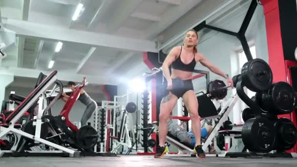 Atleta levanta una pesada mancuerna en un gran gimnasio profesional. — Vídeos de Stock