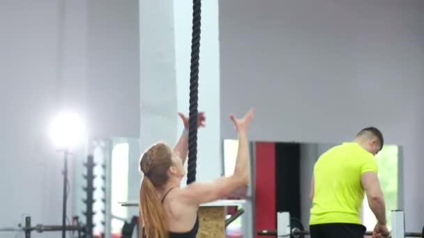 Sağlıklı kadın halata tırmanıyor, yoğun antrenman yapıyor, güçlü bir sporcu. — Stok video