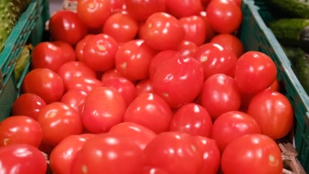 Tomatoes in the market in boxes, close up panning on a big pile of red fruits. — Vídeos de Stock