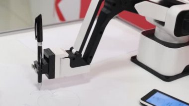 Modern bir robot tükenmez kalemle resim çiziyor.